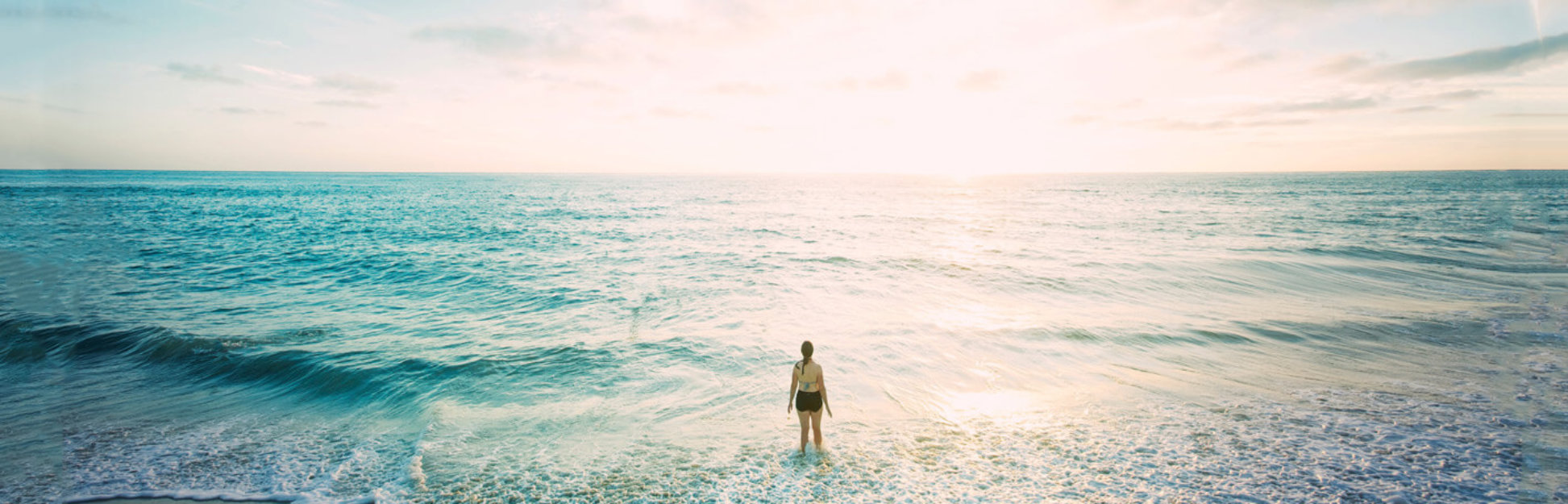 Women in the ocean at sunset